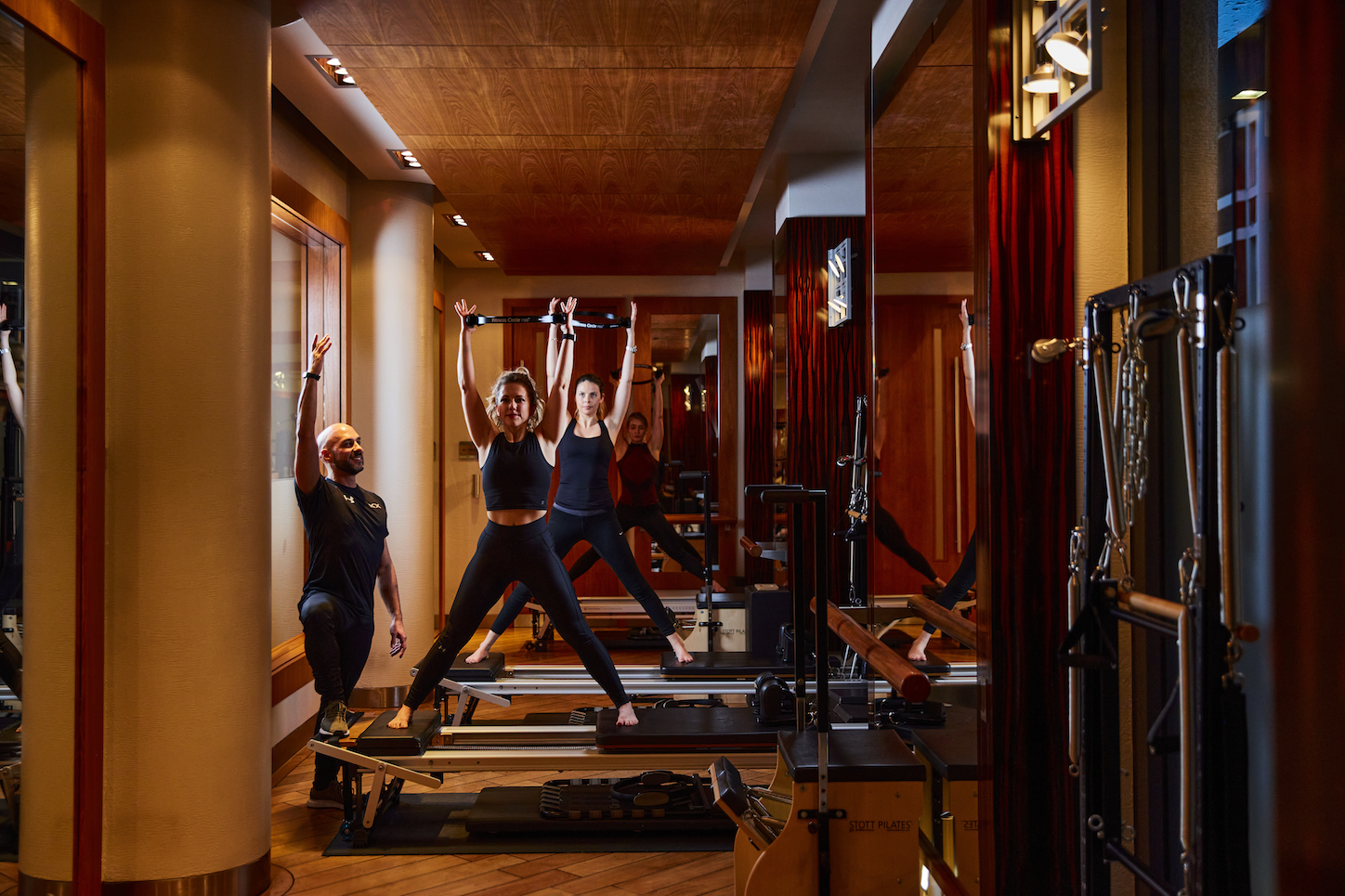 Women doing cores pilates exercises with a PT