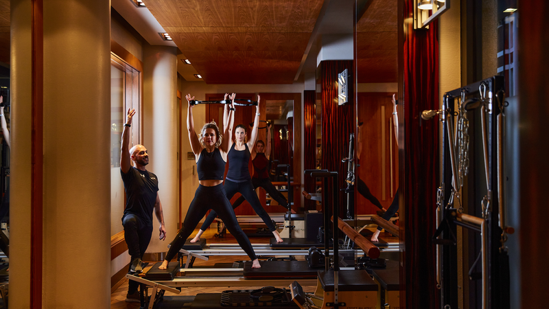 Women doing cores pilates exercises with a PT